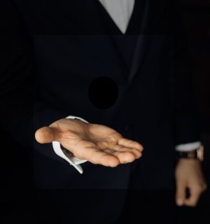 man-black-suit-is-tossing-two-wedding-rings-2-scaled-qlhzbd1svq4918yh3rxb11zgjn9depciqtl8a4xqbk